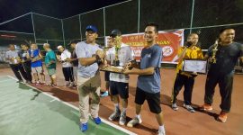 Pj. Bupati Lotim Juani Taofik Tunjukkan piala kemenangan kejuaraan Tennis HUT Bhayangkara Polres Lotim