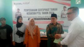 Kanwil BPN Provinsi NTB Lutfi Zakaria, S.IP., M.H menyerahkan ratusan sertifikat tanah secara simbolis kepada warga desa Sukamulia. (Foto: Harian Lombok).